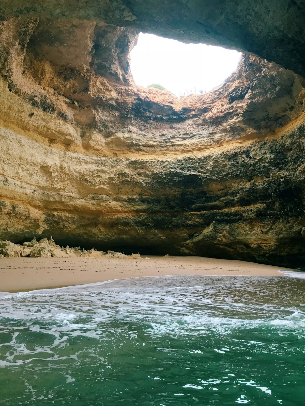 Interior of Benagil Cave (Algar de Benagil) with domed ceiling oculus and turquoise water, Algarve, Portugal