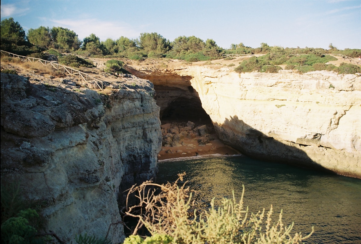 Coastal cliffs with a cave entrance and calm turquoise water at Benagil, Algarve, Portugal