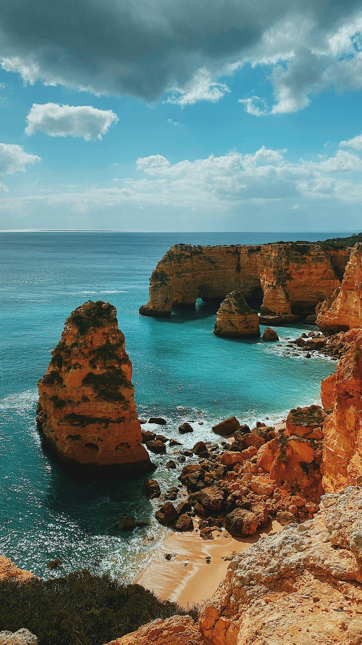 Golden limestone cliffs and clear turquoise water at Praia da Marinha in the Algarve, Portugal