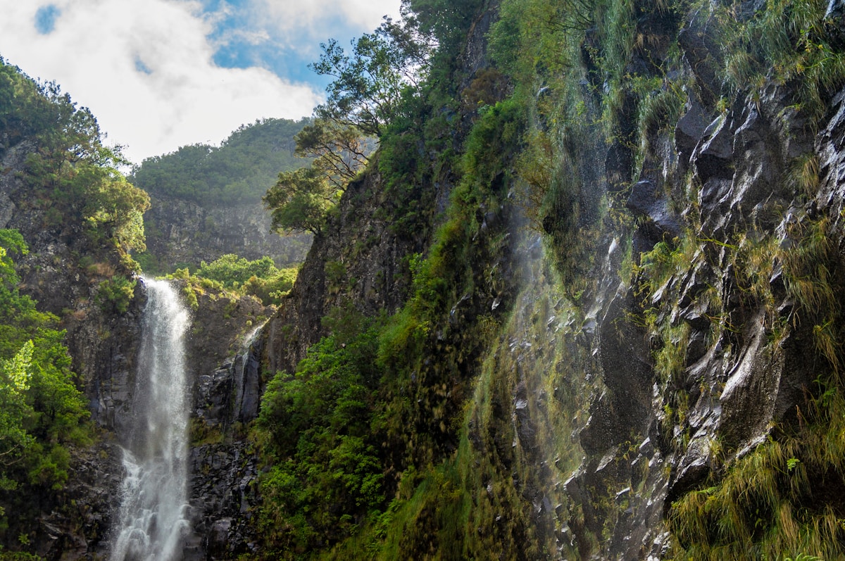 Waterfall cascading down green volcanic rock at 25 Fontes Falls, Madeira, Portugal