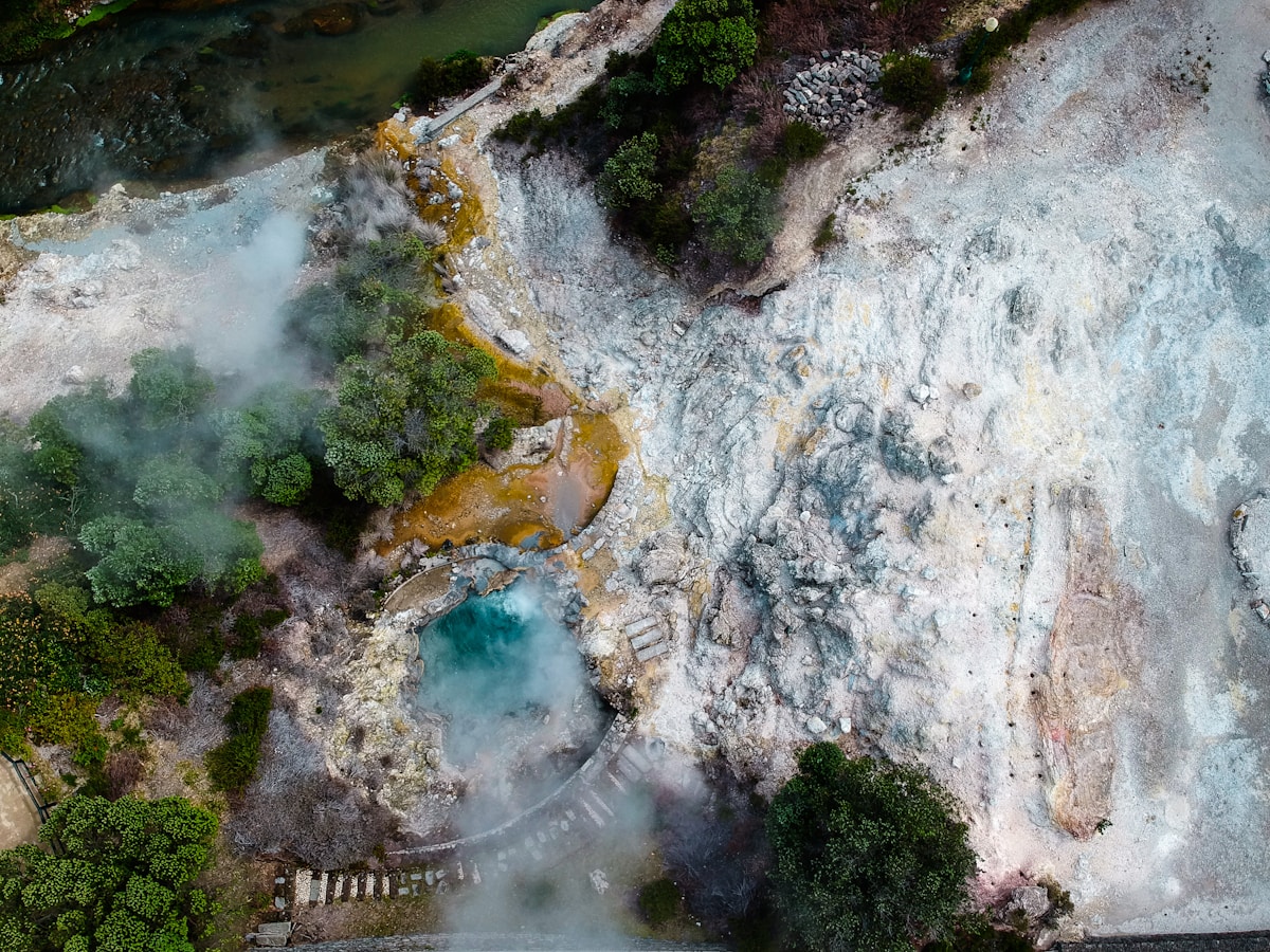 Aerial view of Furnas geothermal pools with steam rising from sulfuric terrain, São Miguel, Azores, Portugal