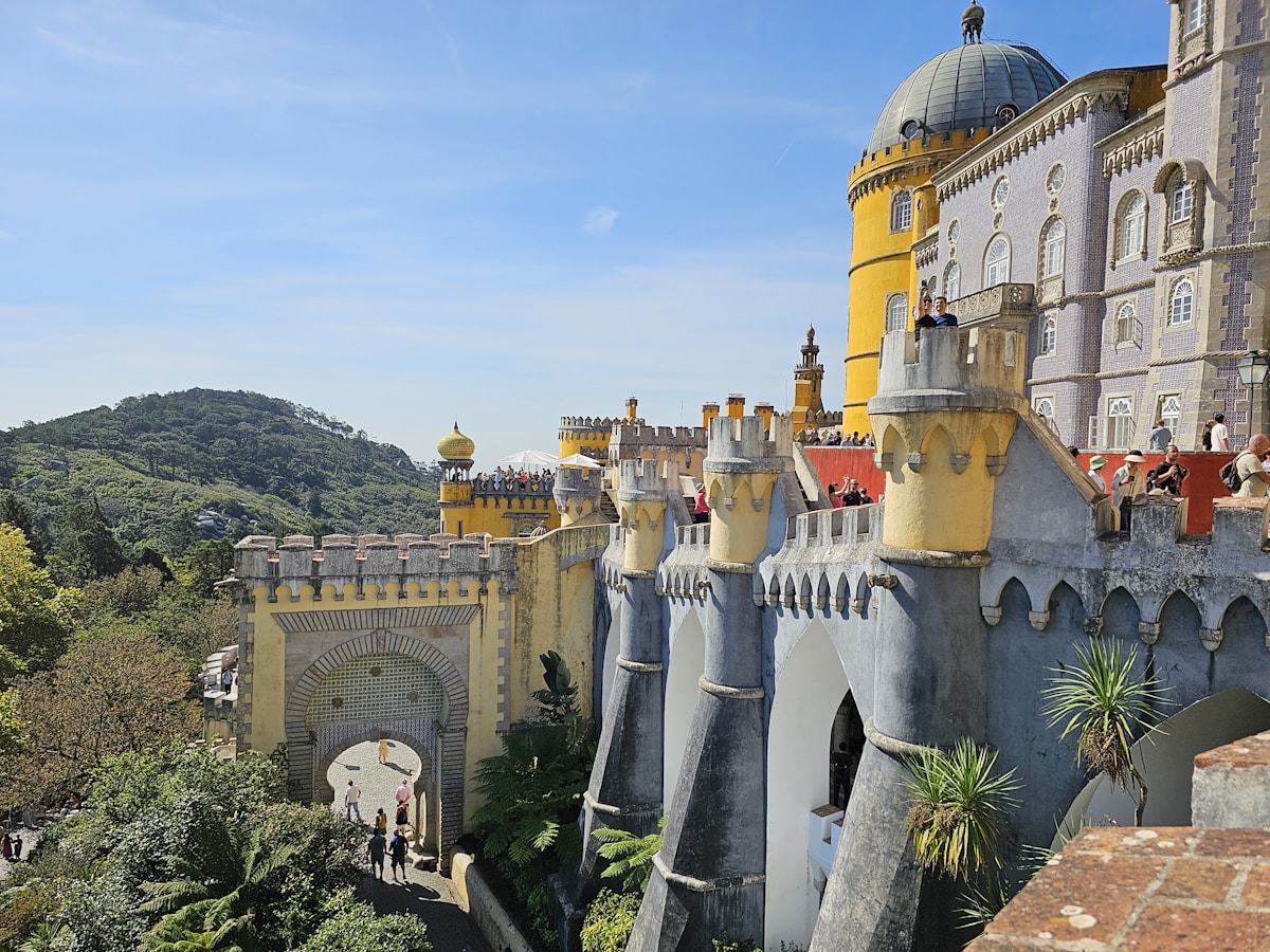 Pena Palace yellow and red castle towers rising above terraces in Sintra, Portugal