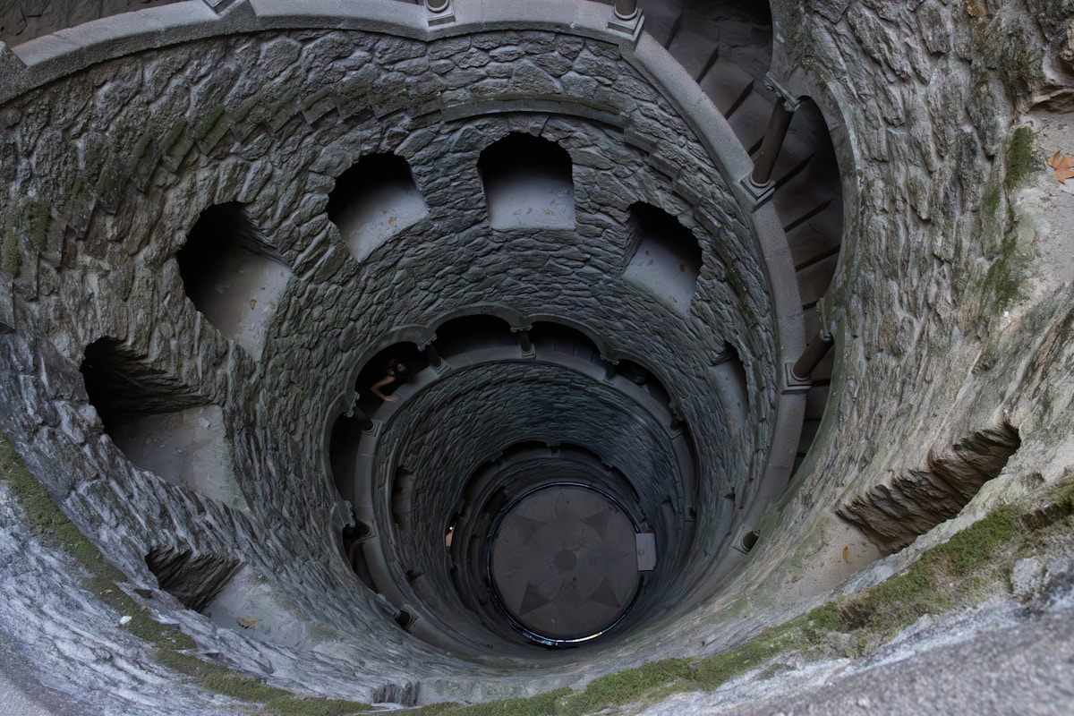 Aerial view looking down into the circular Initiation Well spiral staircase at Quinta da Regaleira, Sintra, Portugal