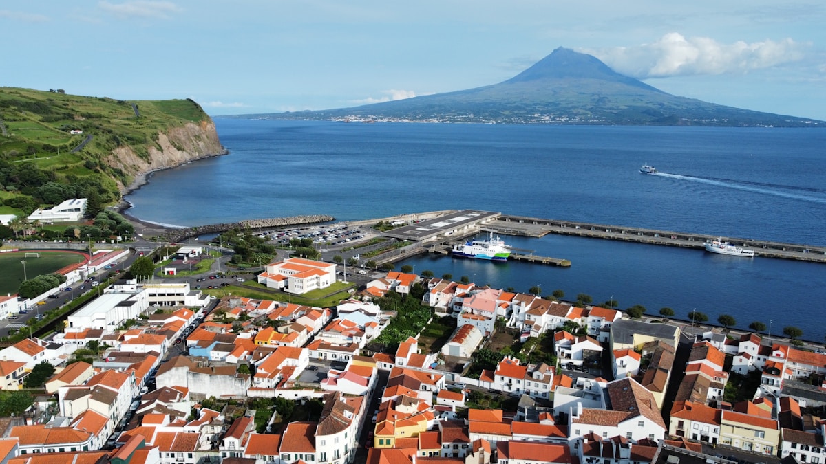 Aerial view of Horta harbour with Pico mountain rising across the channel, Faial island, Azores, Portugal