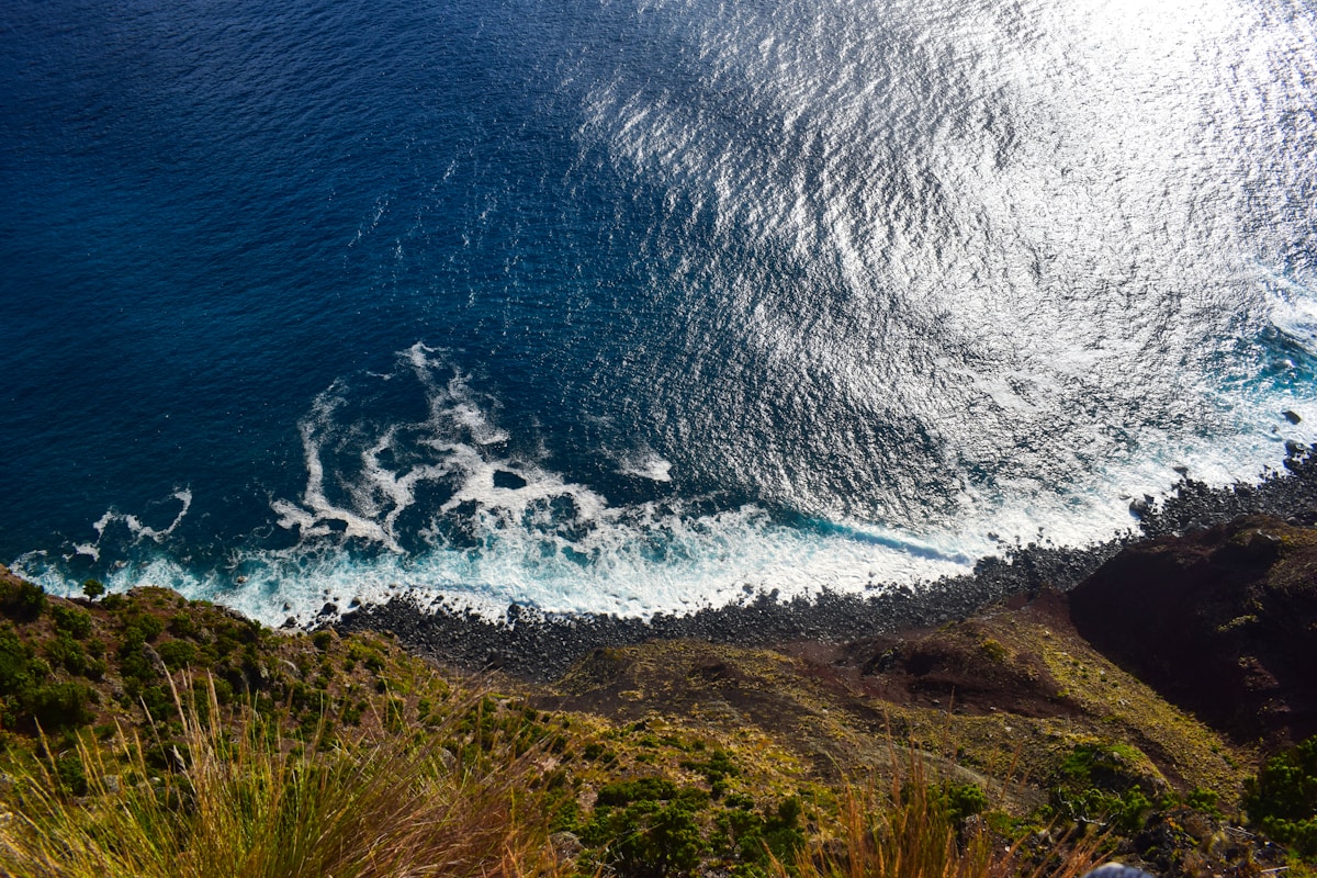 Rocky volcanic coastline viewed from above with Atlantic Ocean waves breaking below, São Jorge island, Azores, Portugal