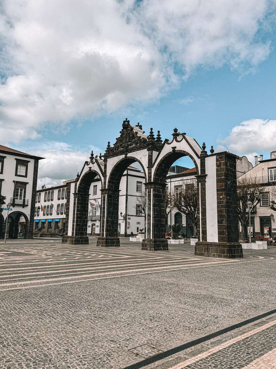 Bunte Straße mit Außencafés und einer Barockkirche in Ponta Delgada, São Miguel, Azoren, Portugal