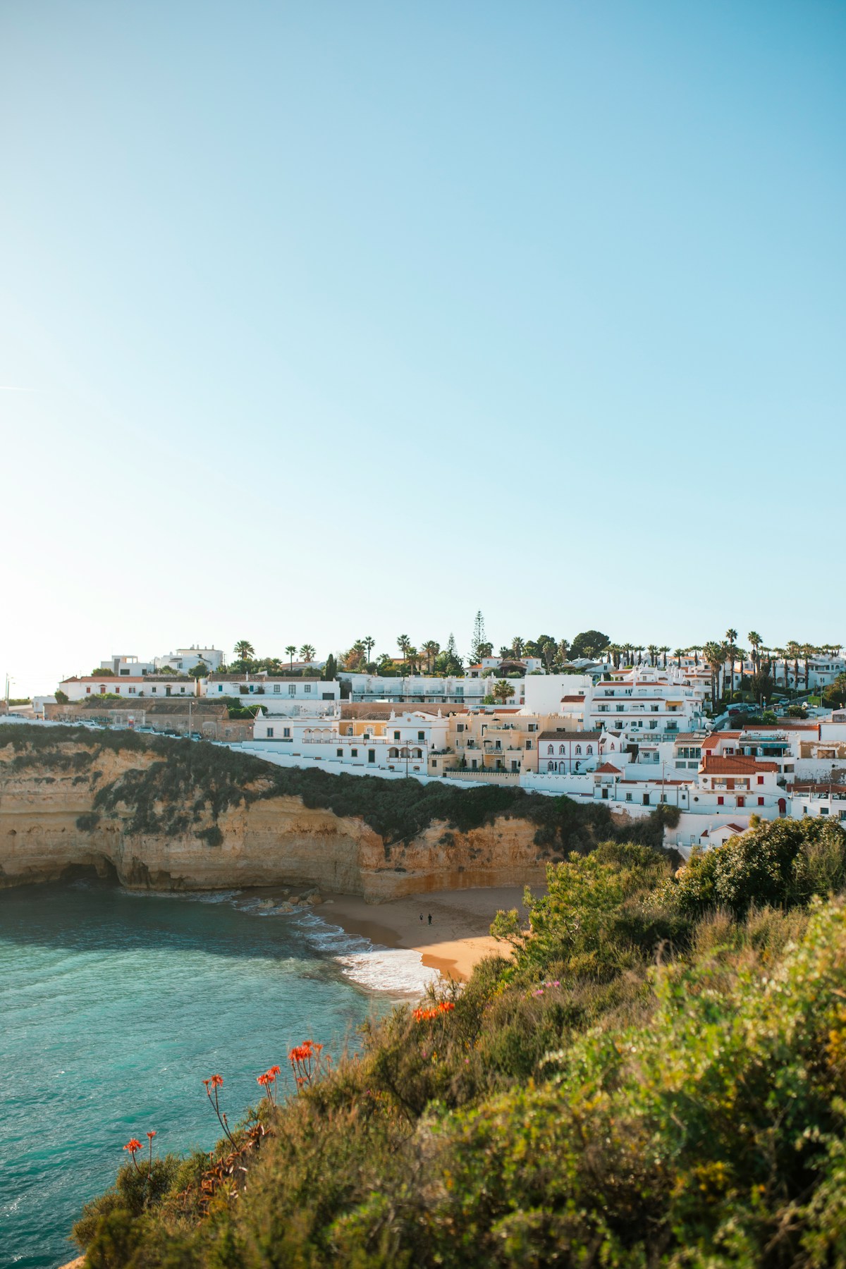 Whitewashed village buildings on the clifftop above Carvoeiro beach, Algarve, Portugal