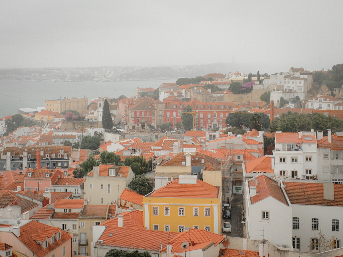 Lisbon's terracotta rooftops and the Tagus River seen from a miradouro on a misty day