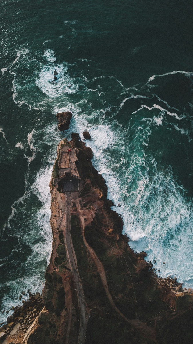 Aerial view of the Fort of São Miguel Arcanjo lighthouse on a rocky promontory at Nazaré, Portugal