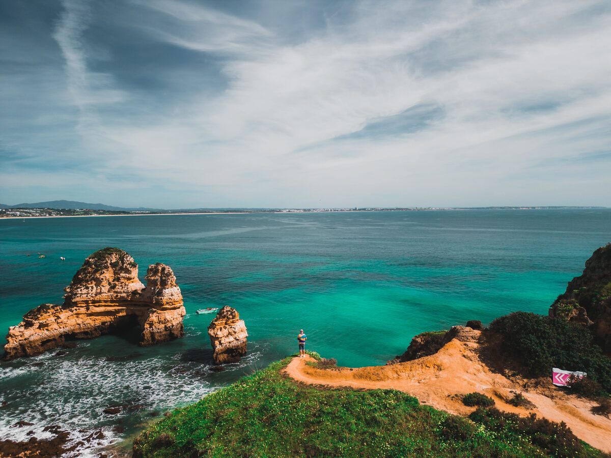 Luftaufnahme der Küste von Lagos mit goldenen Felsformationen und türkisfarbenem Meer, Algarve, Portugal