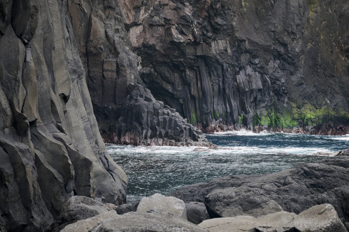 Dark basalt volcanic cliffs with crashing Atlantic waves on São Jorge island coastline, Azores