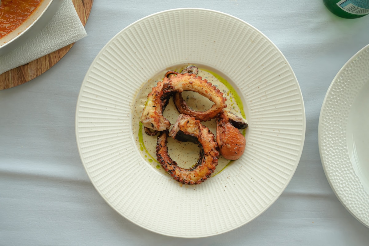 Grilled octopus tentacles served in a white bowl - fresh Atlantic seafood, Flores island, Azores