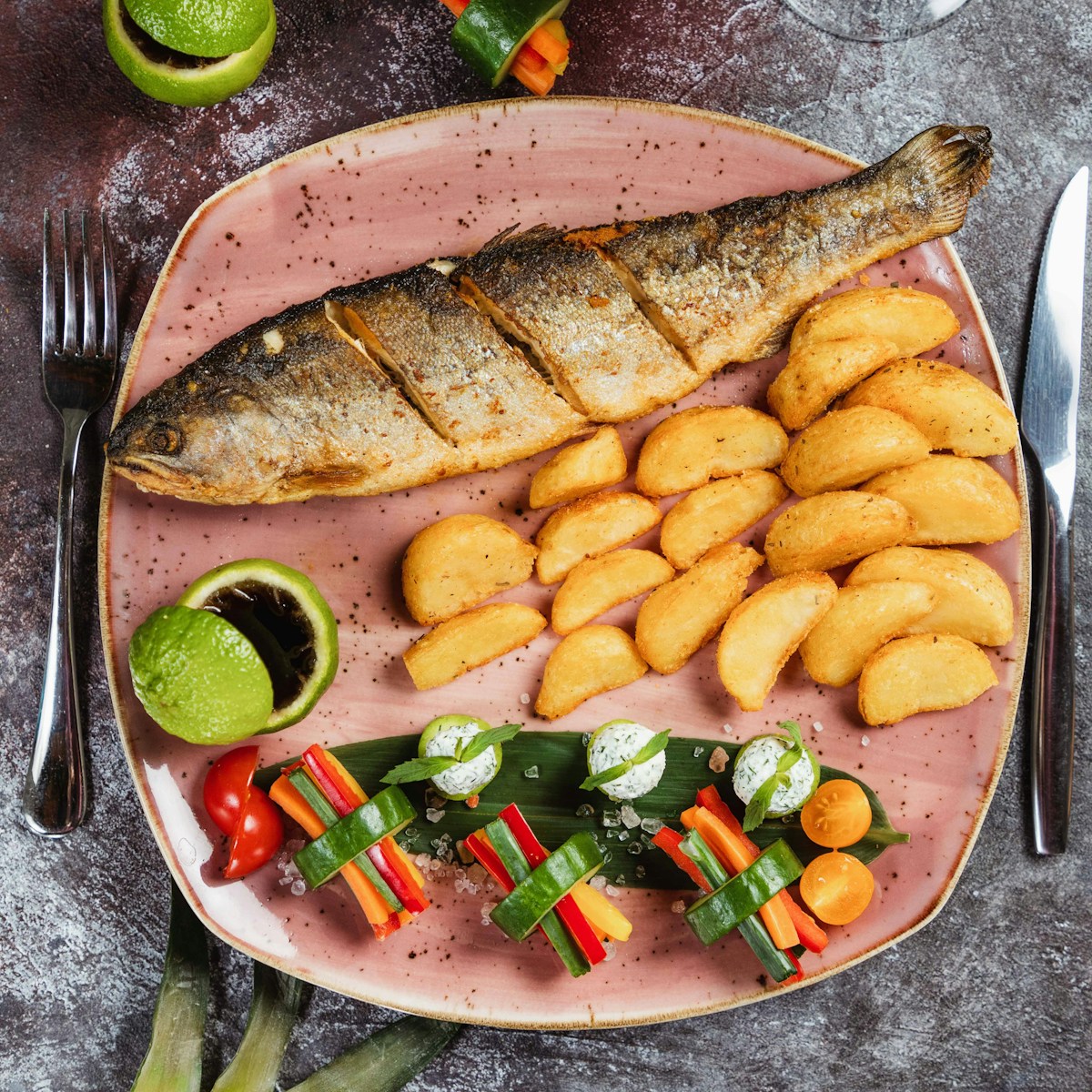 Whole grilled fish with roasted potatoes and colourful vegetables on a plate - fresh seafood in Graciosa, Azores
