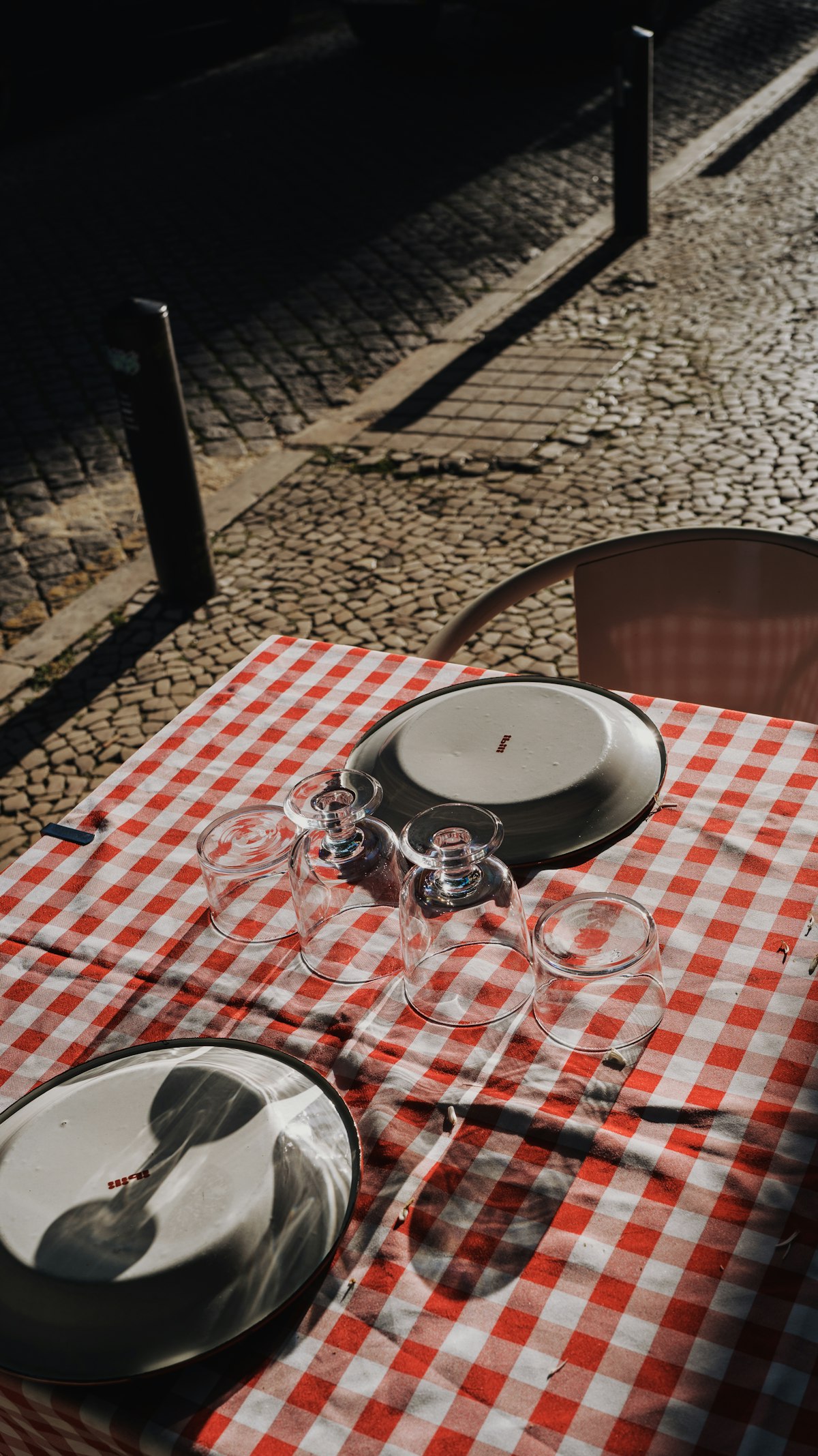 Red and white checkered tablecloth with wine glasses at a traditional Lisbon tasca