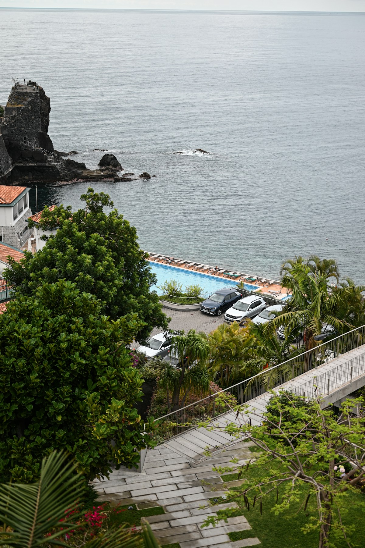 Terrace pool area overlooking the Atlantic Ocean and lava rock coast, Funchal, Madeira, Portugal