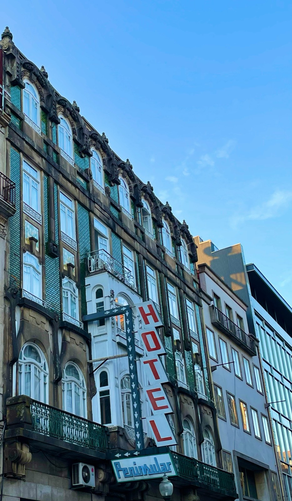 Classic Porto hotel building with azulejo tile facade and red Hotel sign, northern Portugal