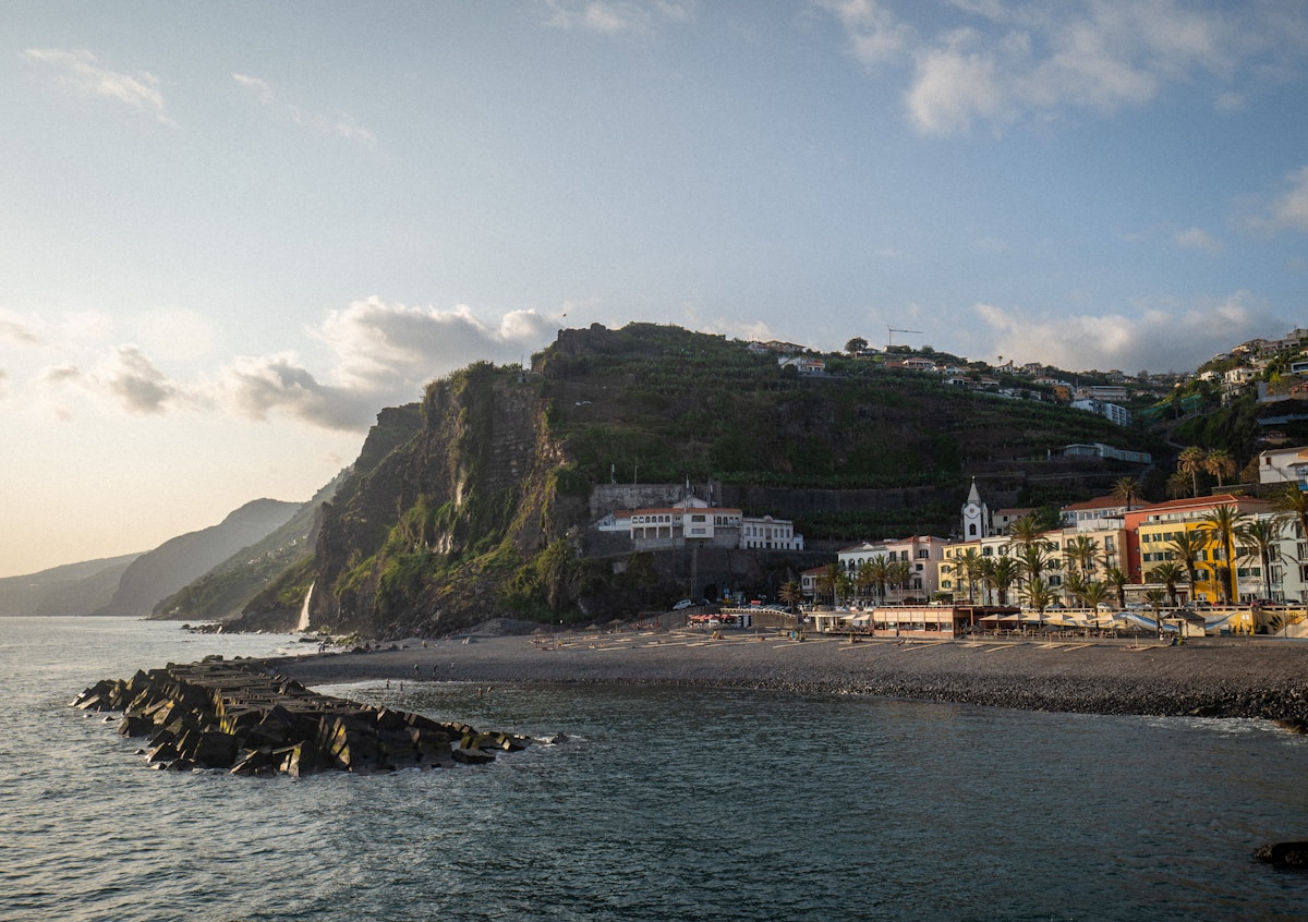 Coastal town of Ponta do Sol at golden hour with volcanic cliffs and Atlantic Ocean, Madeira, Portugal