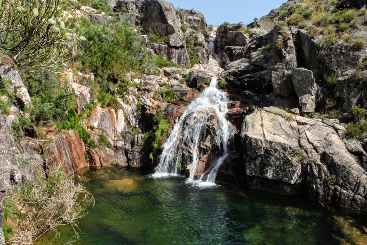 Waterfall cascading over granite rocks into a natural pool in Serra de Gerês, Peneda-Gerês National Park, Portugal