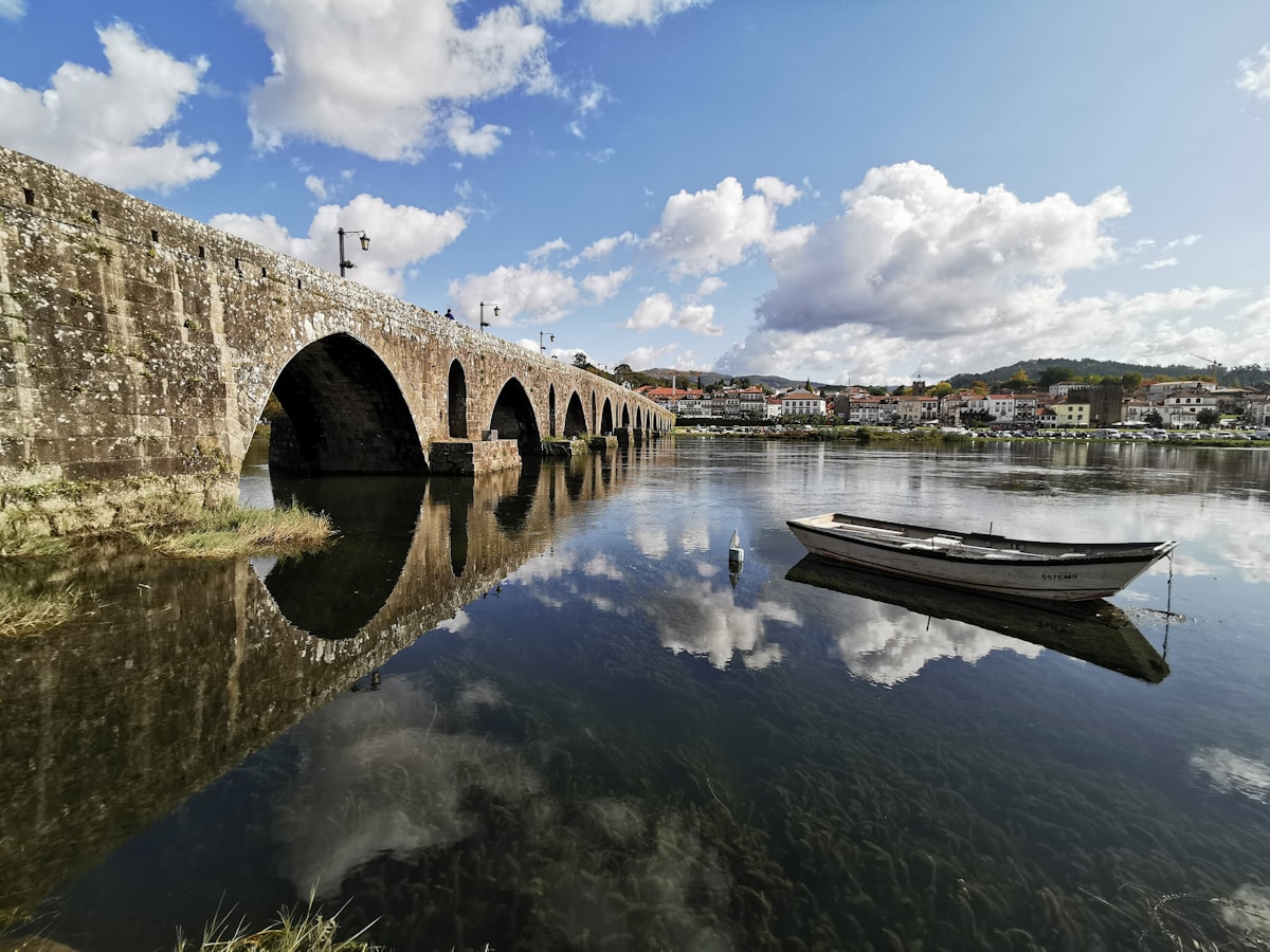 Ancient stone bridge reflected in the Lima river at Ponte de Lima, a scenic day trip from Porto