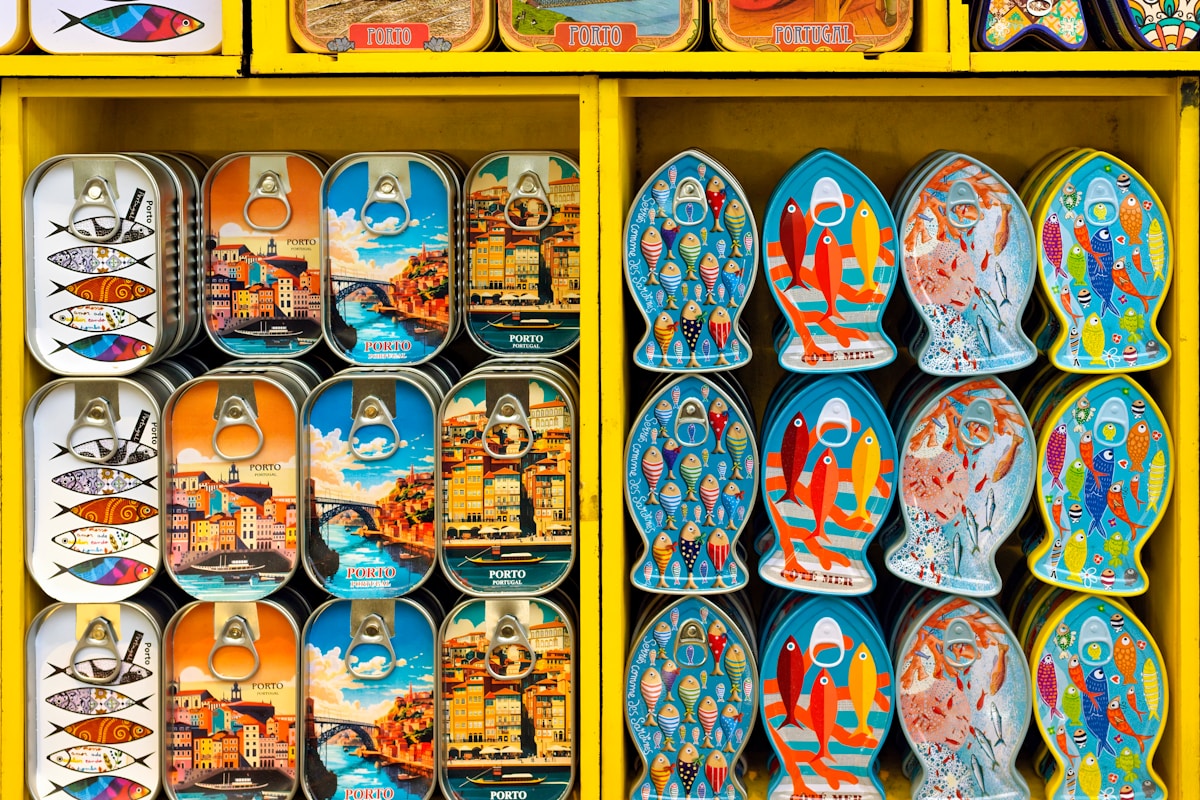 Colourful decorative sardine tin cans on yellow market shelves in Porto, Portugal