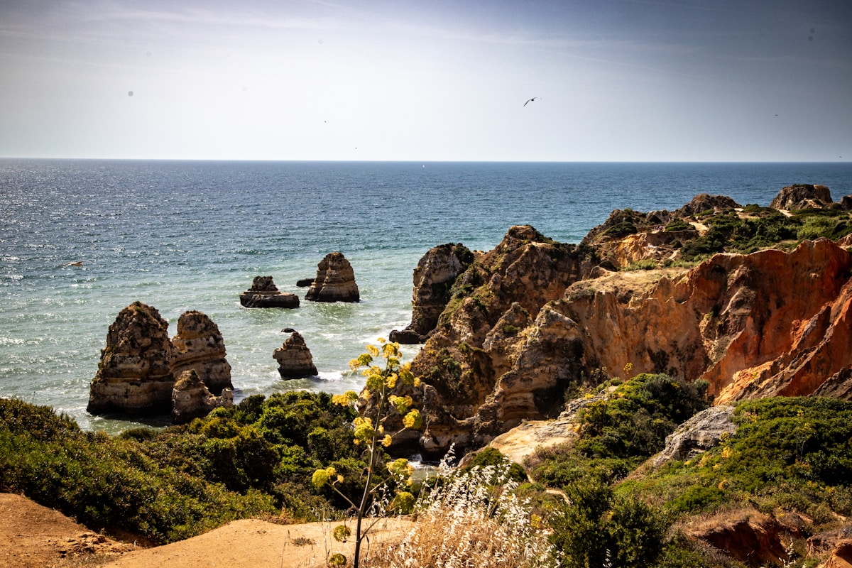 Coastal landscape with sea stacks and golden limestone cliffs, Lagos, Algarve, Portugal