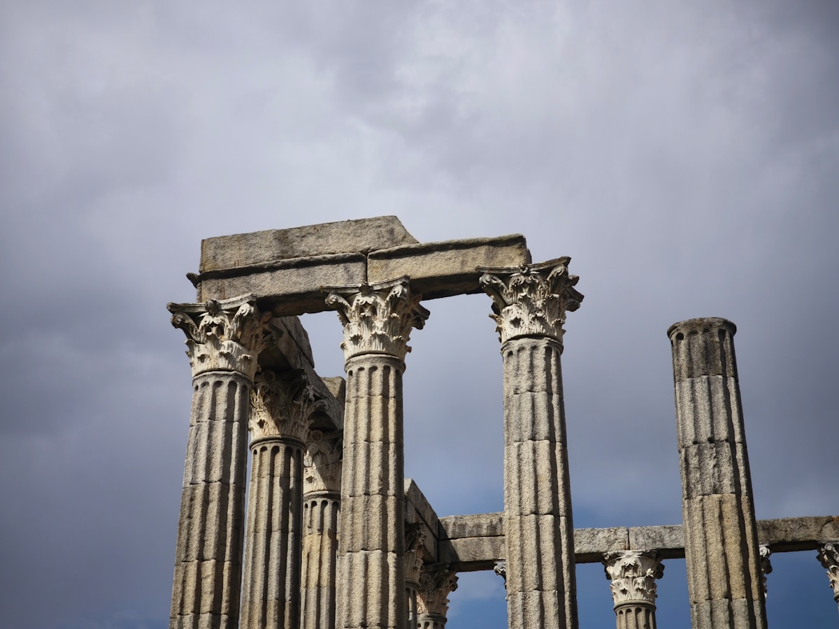 Ancient Roman columns of the Temple of Diana against a cloudy sky, Évora, Portugal