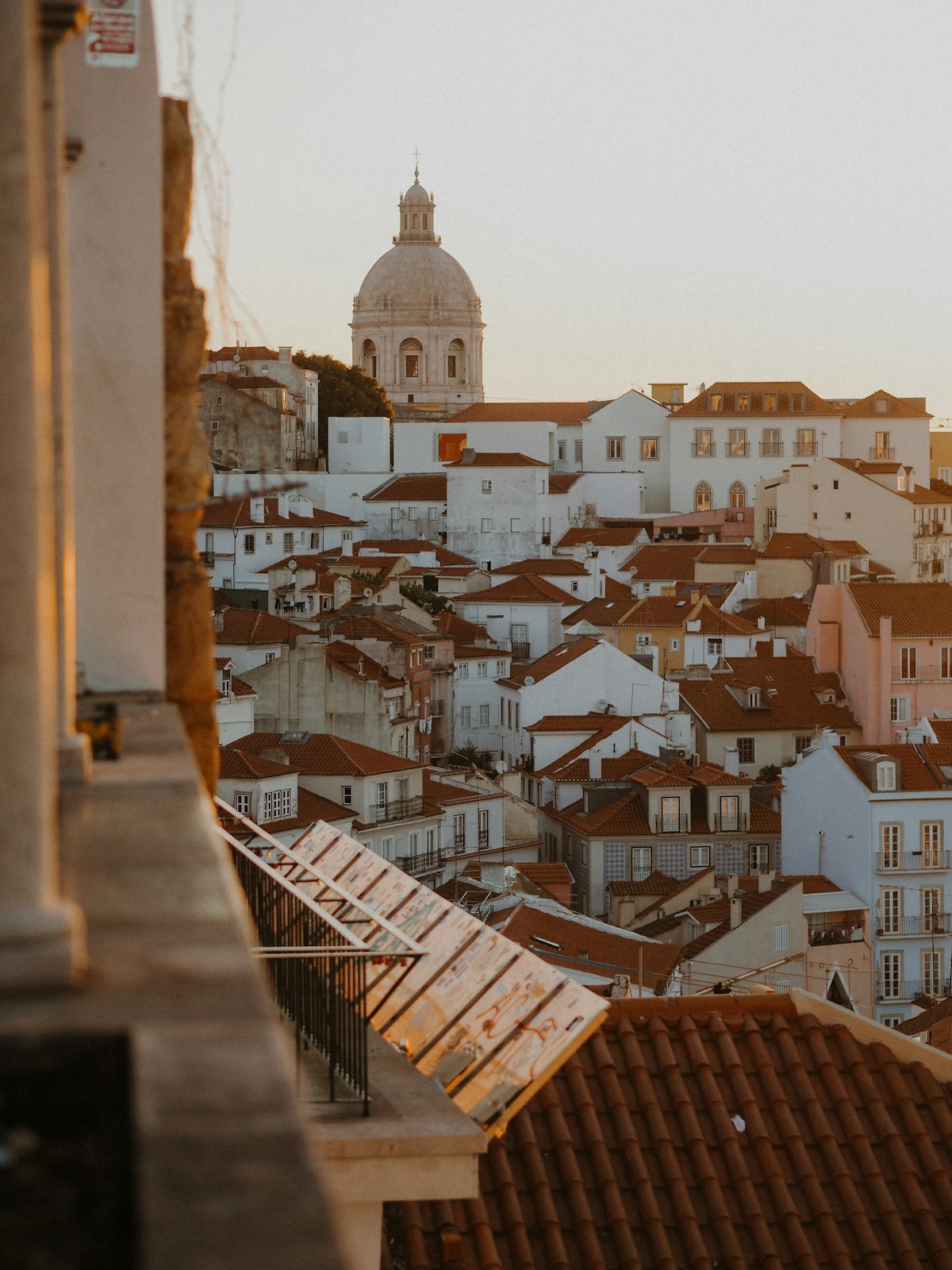 Lisbon rooftop viewpoint with terracotta tiles and the Tagus River in the background