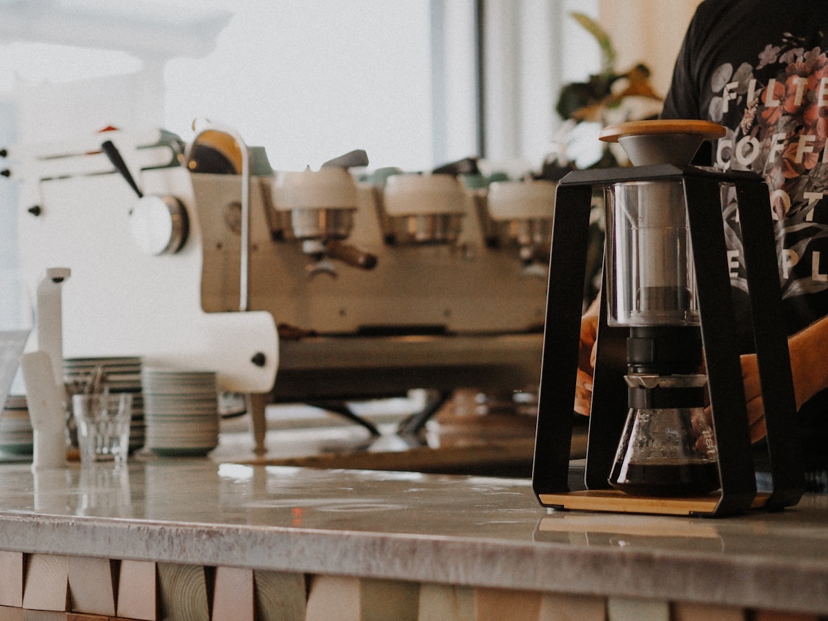 Espresso machine and coffee brewing equipment at Bloom Coffee Room, Lisbon, representing cafe culture and travel costs