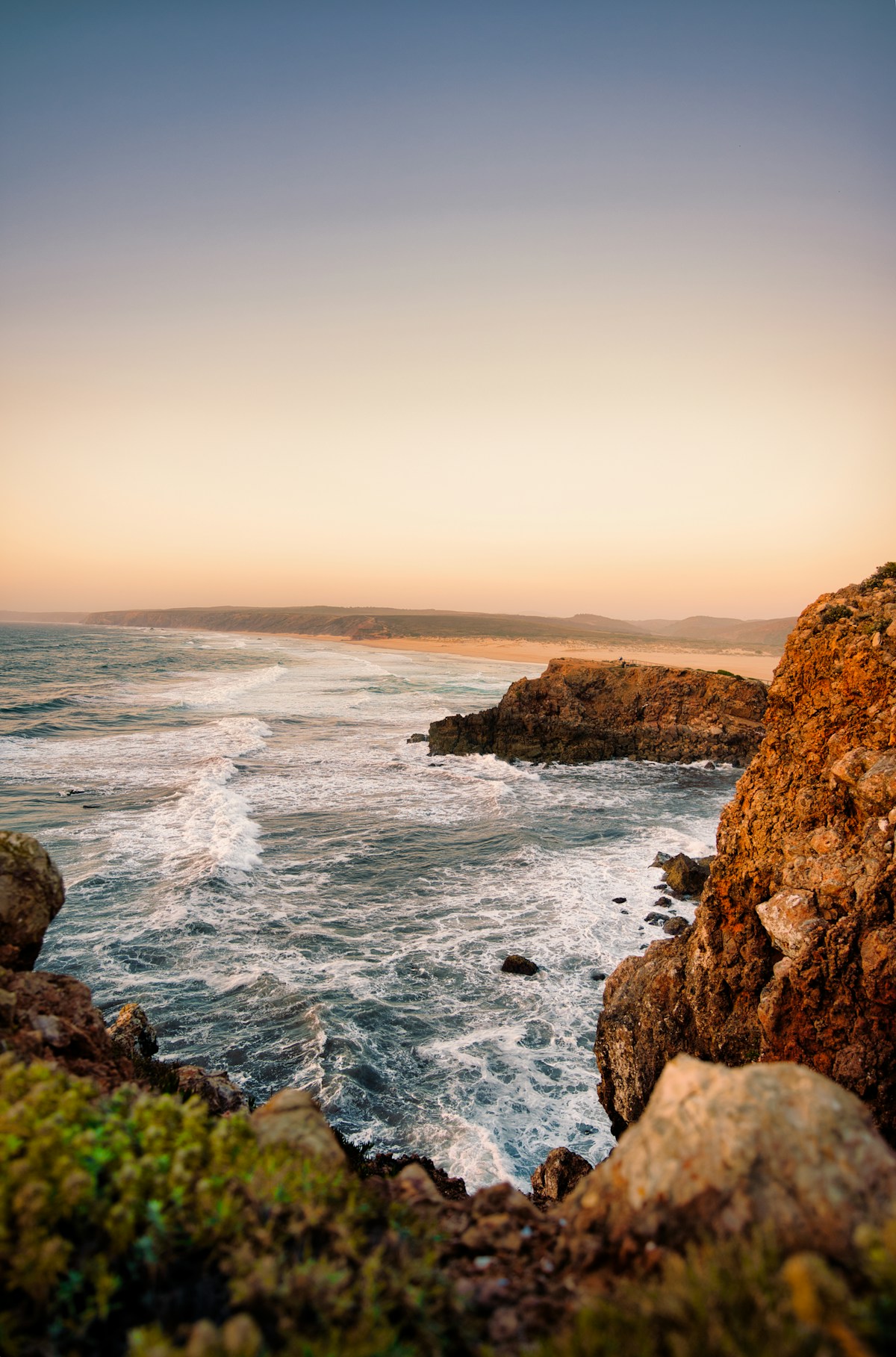 Coastal cliffs and Atlantic waves at sunset at Bordeira beach, Carrapateira, southwest Portugal