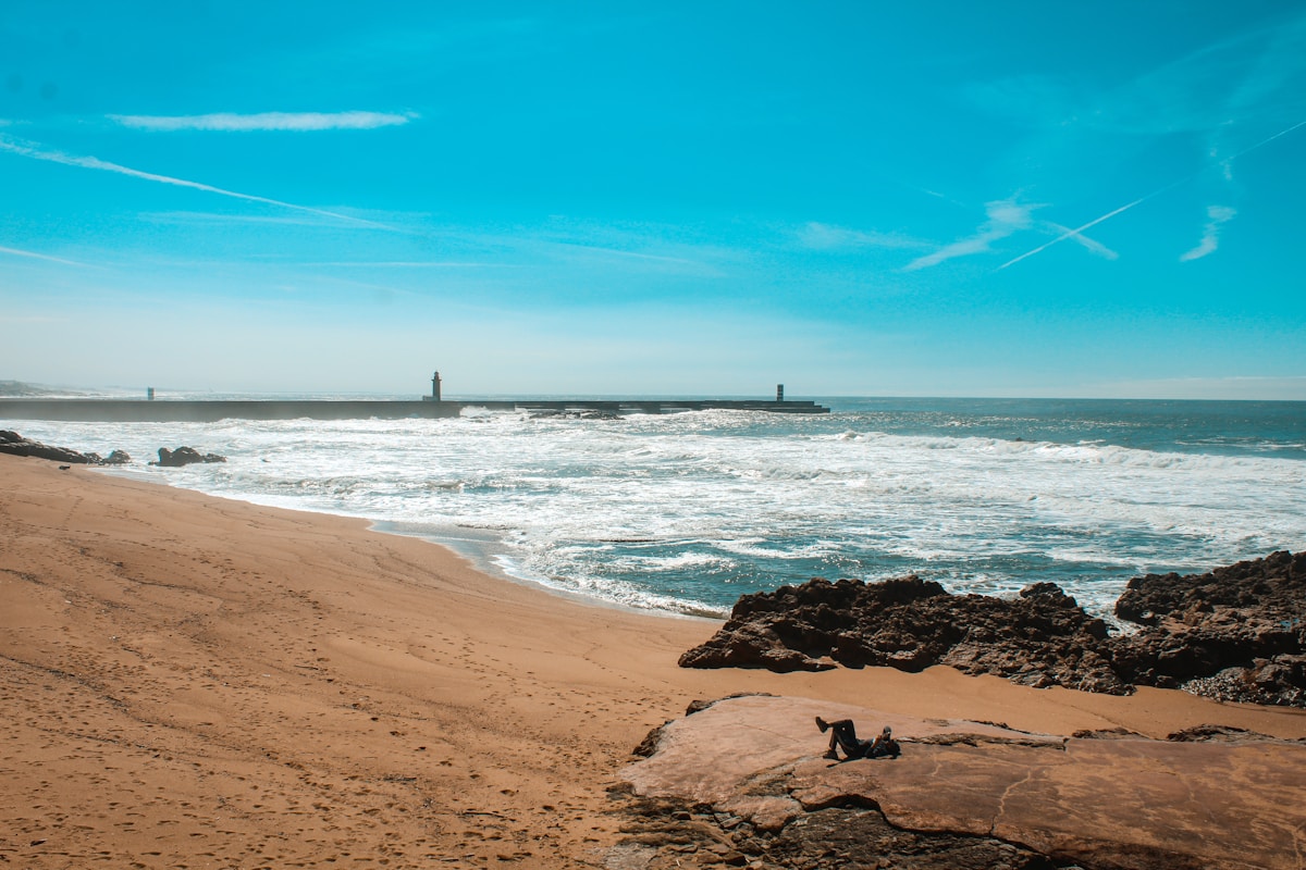 Atlantic beach with lighthouse in the background on the northern Portuguese coast near Porto
