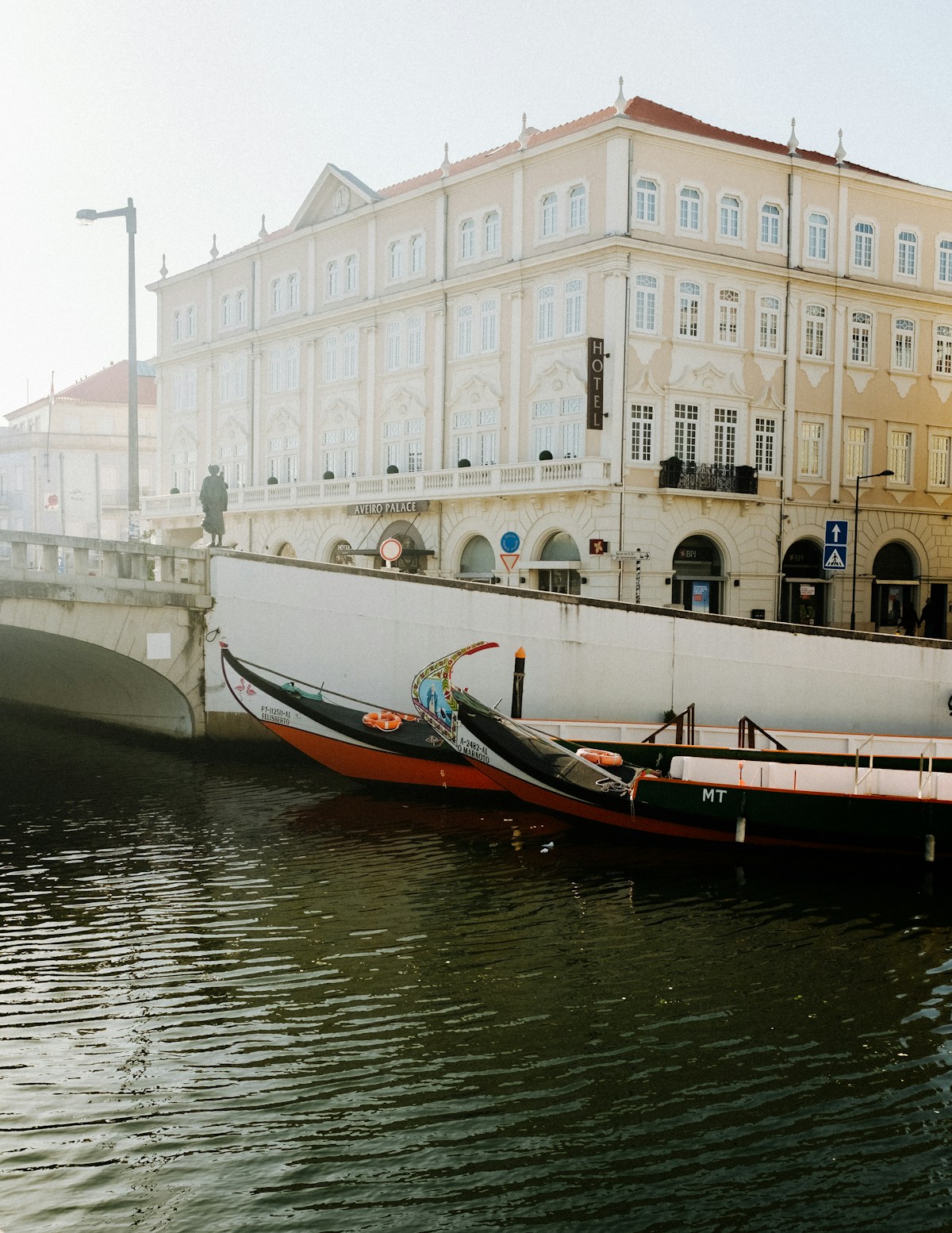 Painted moliceiro boats on Aveiro canal with Art Nouveau buildings behind