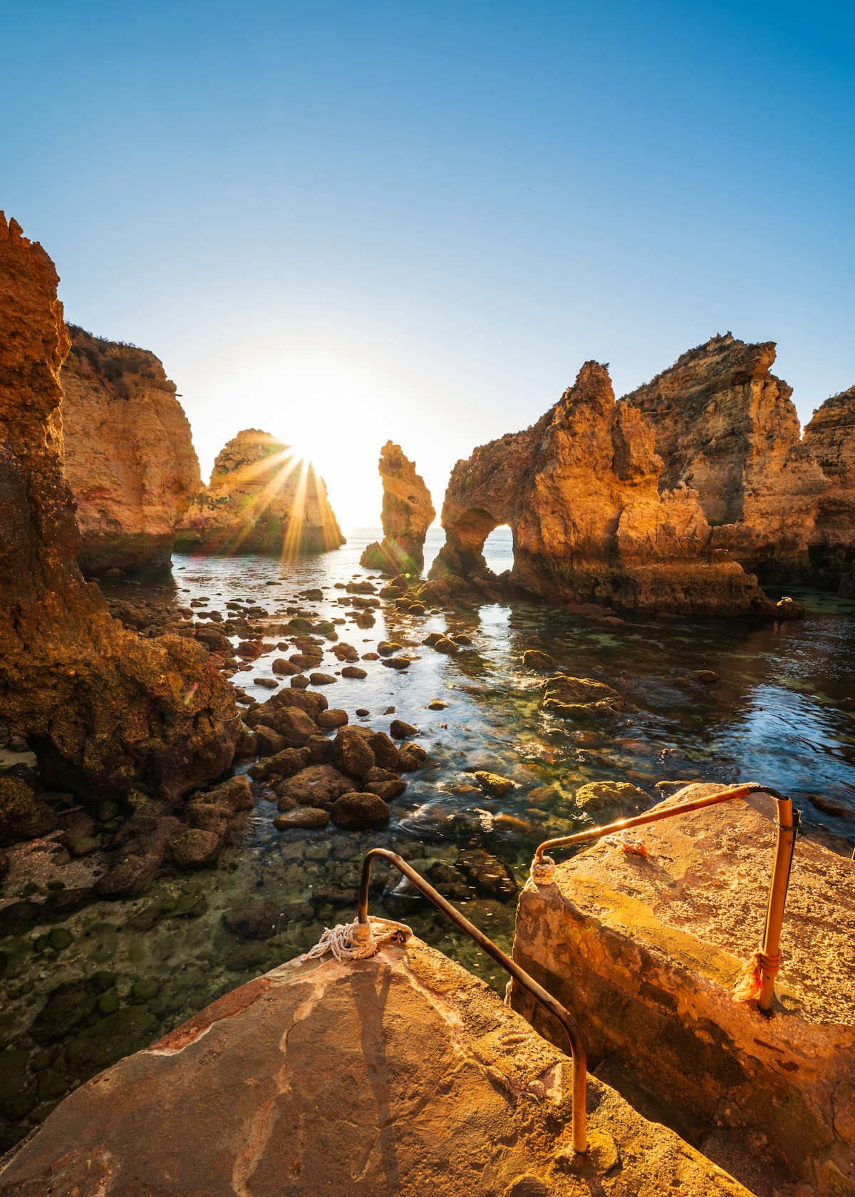 Sunrise illuminating the golden sea arches and caves at Ponta da Piedade, Lagos, Algarve