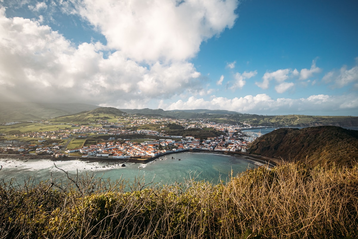 Azorean coastal town and harbour bay viewed from a grassy hilltop, Santa Maria island, Azores, Portugal
